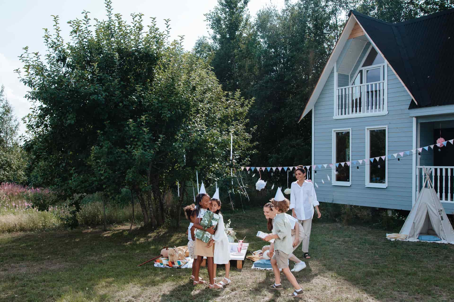 Children playing outside a house at a summer backyard party